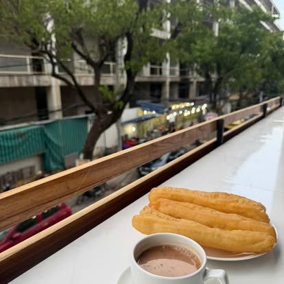 Milk tea and fried dough sticks on the balcony rail, overlooking the street below