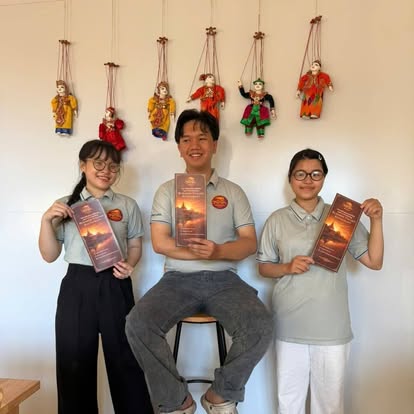 Colorful Burmese yoke thé marionettes hanging above three smiling staff holding menus